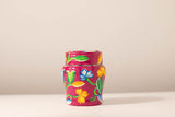 Colorful ceramic jar with floral designs on a beige background