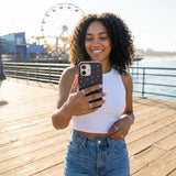 Black Neon Nostalgia iPhone 15 Case - Lifestyle photo showing phone case in use