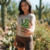 Sage Green Dino Camo iPhone 15 Case - Lifestyle photo showing phone case in use