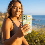 Sage Green Daisy iPhone 16 Pro Case - Lifestyle photo showing phone case in use