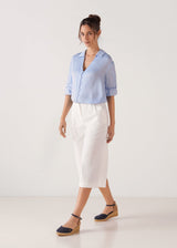 Full-length model wearing navy canvas ankle-strap wedge espadrilles with a natural jute platform