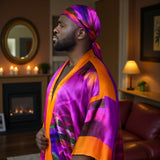Man wearing a colorful Bird of Paradise Pink Purple Silk Kimono with matching head scarf in a cozy living room.