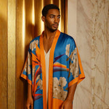 Man wearing a Colorful Bird of Paradise White Blue Cherry Blossom Silk kimono garment with abstract patterns against a neutral background