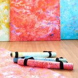 Kati Kaia stylish travel yoga mat UK rolled up in vibrant colours on wooden floor