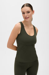 Model wearing the L’Original tank in olive green color, made from OEKO-TEX® certified compression fabric featuring MicroPerle® technology along the back to promote lymphatic drainage, improve circulation, and reduce fatigue.