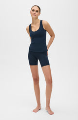 Model wearing the L’Original Bike Short with matching tank in navy blue, made from OEKO-TEX® certified compression fabric featuring Elastique’s MicroPerle® technology to promote lymphatic drainage, enhance circulation, reduce fatigue, and smooth the skin.