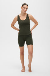 Model wearing the L’Original Bike Short with matching tank in Olive green, made from OEKO-TEX® certified compression fabric featuring Elastique’s MicroPerle® technology to promote lymphatic drainage, enhance circulation, reduce fatigue, and smooth the skin.