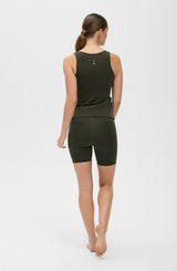 Model wearing the L’Original Bike Short with matching tank in Olive, made from OEKO-TEX® certified compression fabric featuring Elastique’s MicroPerle® technology to promote lymphatic drainage, enhance circulation, reduce fatigue, and smooth the skin.