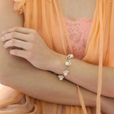 The Venus white pearl dangle gold chain bracelet is handmade in our studio with sustainable materials. The gold chain really enhances the colour of the natural glossiness of the white baroque pearls all wire wrapped into little dangles around the chain.