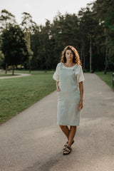 Front Of Women Wearing A Green Mint Linen Apron Dress With White Top