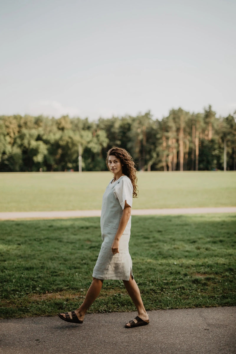 Side Of Women Wearing A Green Mint Linen Apron Dress With White Top