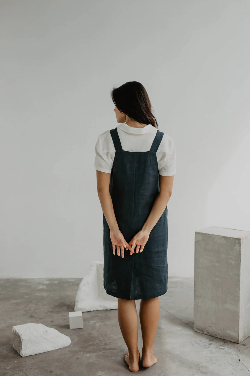 Back Of Women Wearing A Black Linen Apron Dress