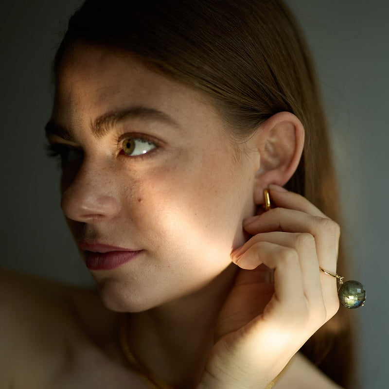 The Bubble Labradorite Ring features a stunning large round green/blue gemstone, attached to a size adjustable gold ring band. This allows the stone to move freely around your finger making this a unique ring.