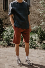 Front Facing Man With A Black OVersized Linen T-Shirt and Terracotta Linene Shorts