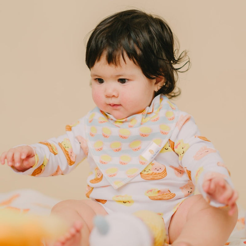 cute child wearing dim sum onesie and egg tart bib