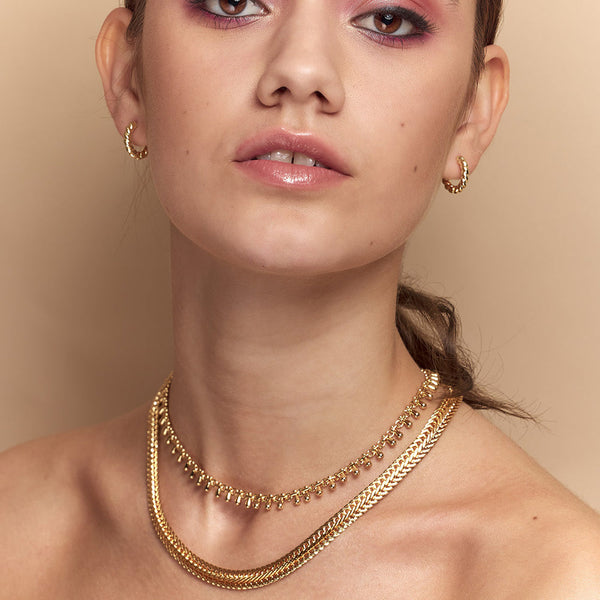 The vintage inspired Anna Snake Chain Gold Necklace is a modern classic that sits flat on the neck and is the ideal for layering.