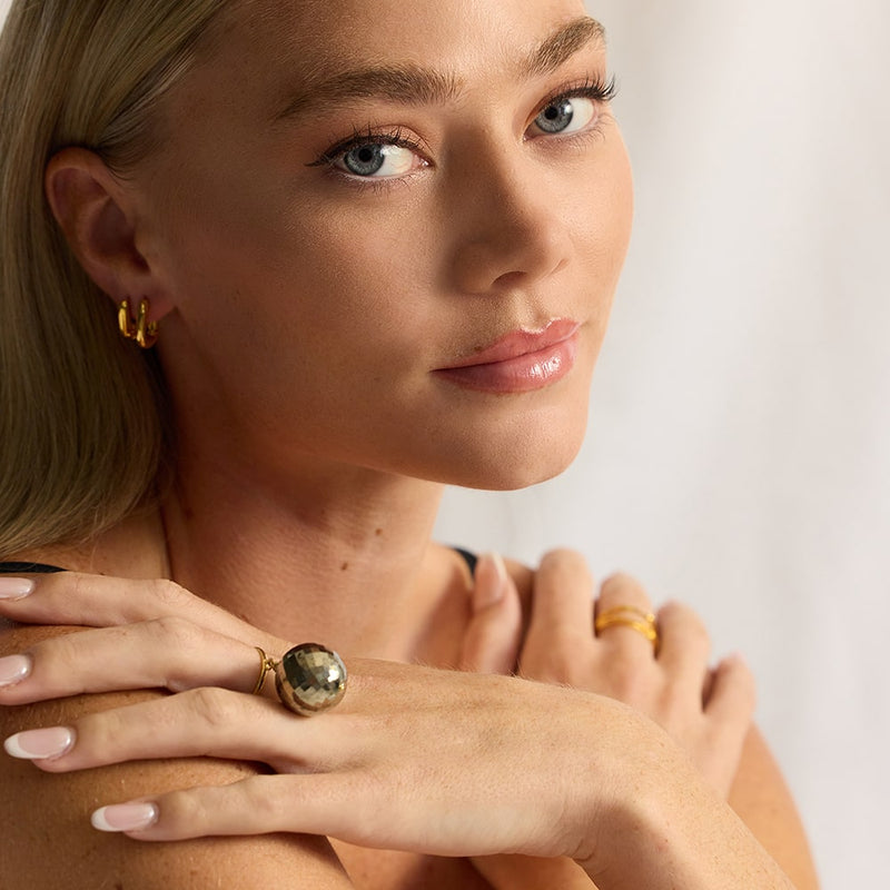 The Bubble Pyrite Ring features a round gemstone with a metallic luster and pale brass-yellow hue that resemblance gold. The gold ring band is fully size adjustable andallows the vintage gemstone to move freely around your finger making this a unique ring.