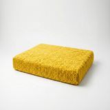 Yellow textured cushion on a white background