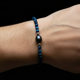 Man's wrist wearing Blue Tigers Eye Black Pearl Bracelet - pearl slightly bigger than beads