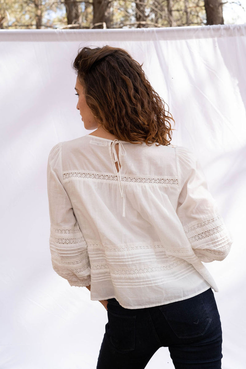 Dawn Blouse in cloud white color for women by Paneros Clothing. From soft cotton voile with pin tucks and lace trim. Back View.
