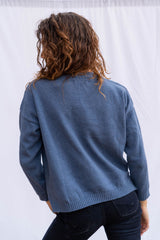 Jolene vee neck handknitted sweater in vintage navy blue for women by Paneros Clothing. Featuring side slits, relaxed fit, and a v neckline from 100% cotton. Back View.