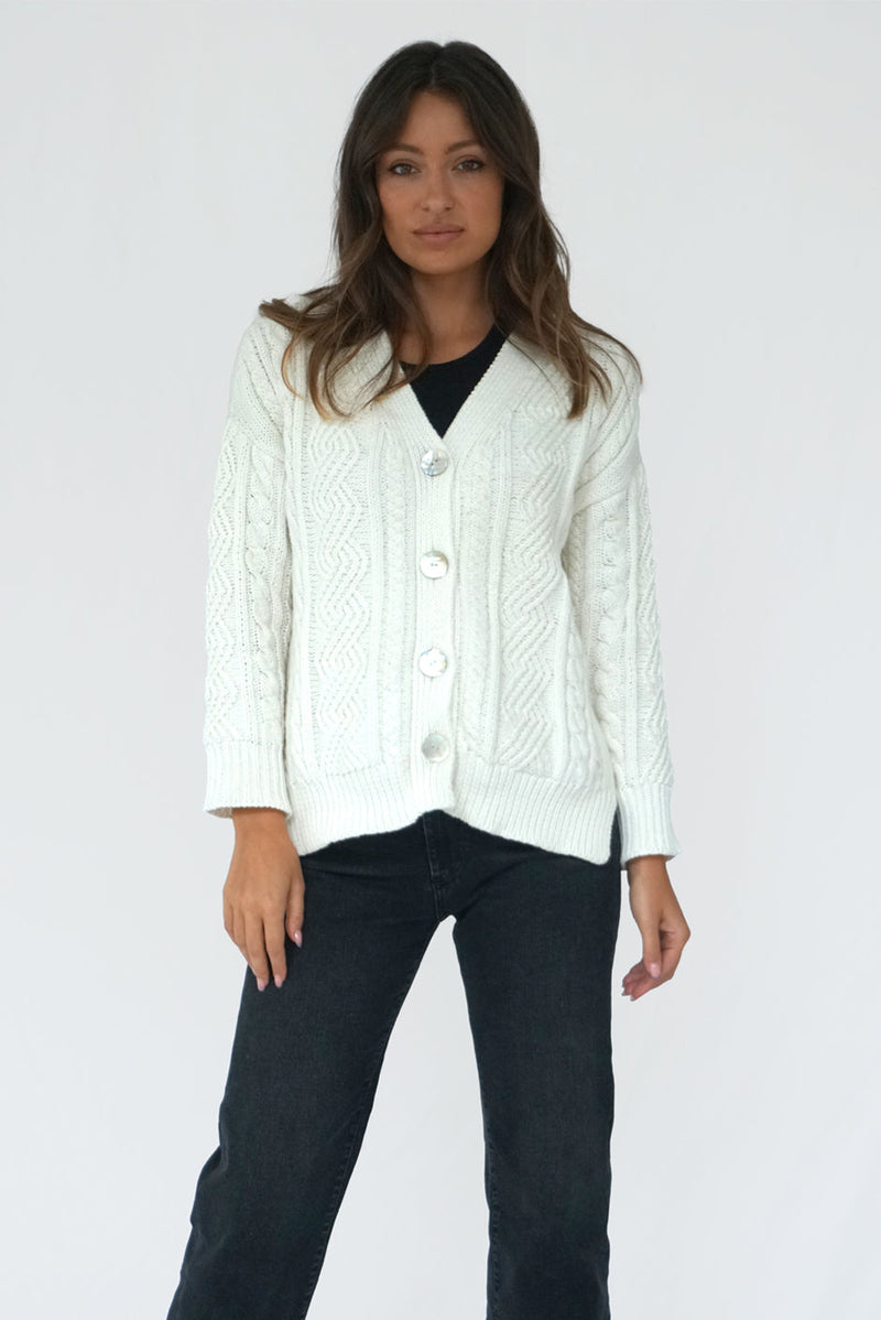 Off-White Long Sleeve Women's Cable-knit Button-up Cardigan Sweater from Paneros Clothing with 100% certified sustainable Cotton and handknitting. Front View buttoned up.