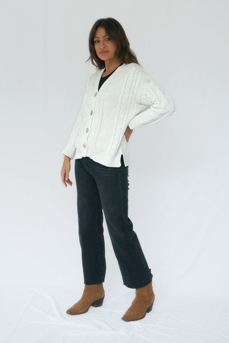 Off-White Long Sleeve Women's Cable-knit Button-up Cardigan Sweater from Paneros Clothing with 100% certified sustainable Cotton and handknitting. Side View.