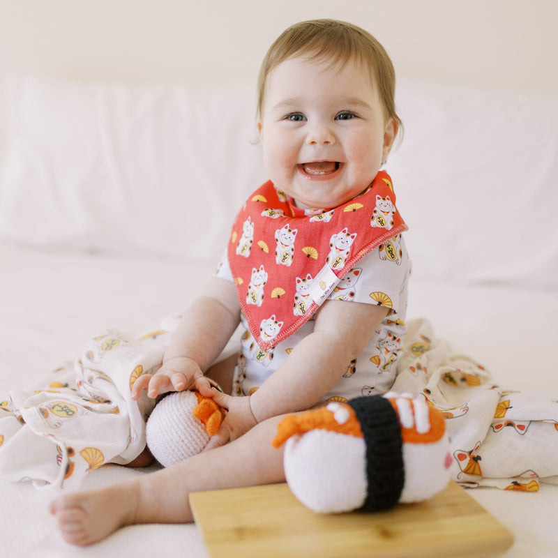 cute baby in the wee bean's lucky cat bib and swaddle with sushi doll