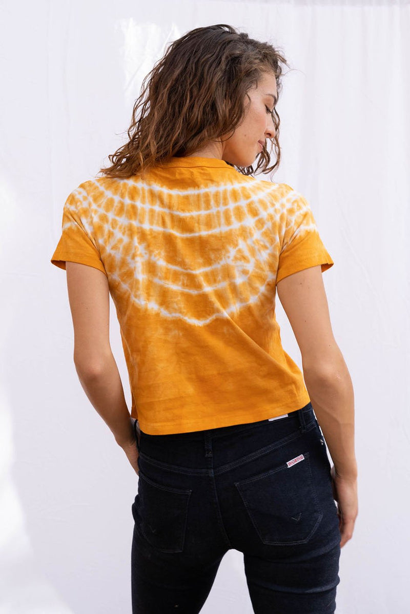 Vintage Cotton Crop Tee in Golden Glow orange color for women by Paneros Clothing. Hand tie-dyed casual top from sustainable cotton. Back View styled with jeans.