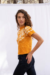 Vintage Cotton Crop Tee in Golden Glow orange color for women by Paneros Clothing. Hand tie-dyed casual top from sustainable cotton. Side View styled with jeans.
