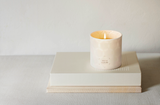 Photo of white isle de nature candle on top of a beige book